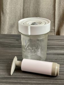 A Suction Airlock Jar and pump sitting on a table.